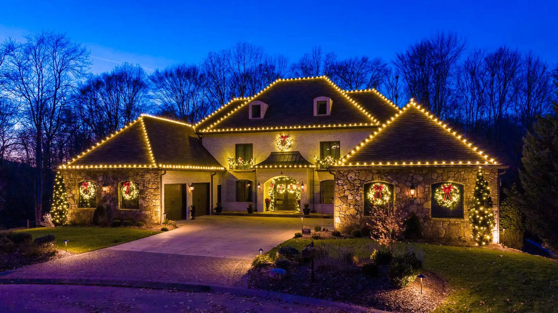 Pensacola home with warm white C9 Christmas lights outlining the roofline and dormers at night
